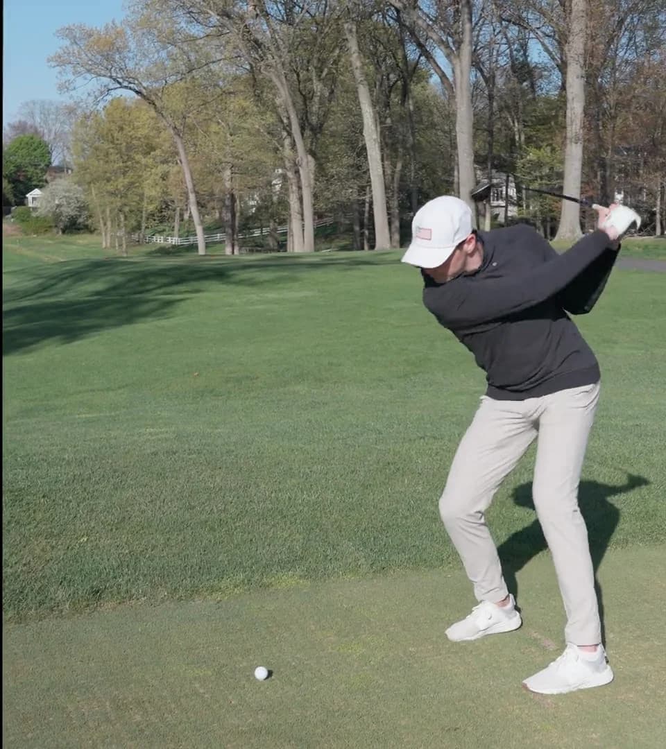 A golfer at the top of the backswing, with a PGA Instructor's notes drawn on the frame